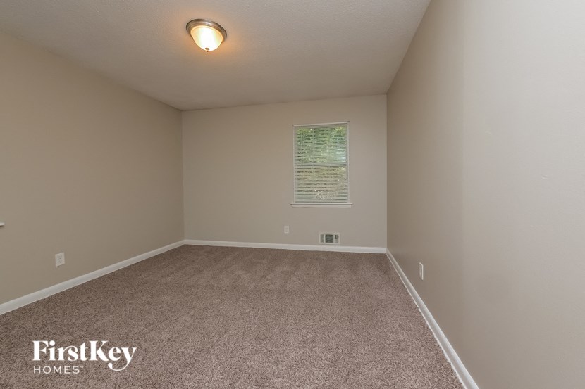 a empty room with carpet and a window