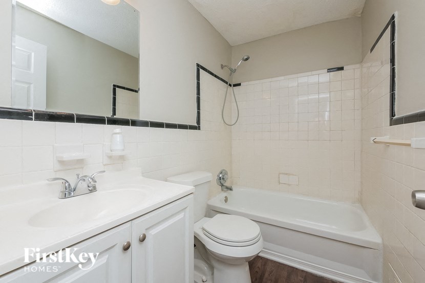 a white bathroom with a sink toilet and bath tub