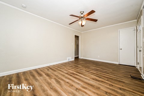 a living room with hardwood floors and a ceiling fan