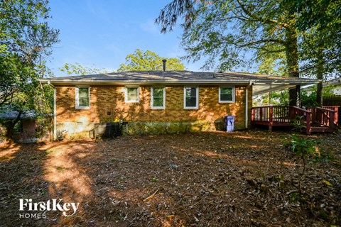 a small brick house with a deck and trees