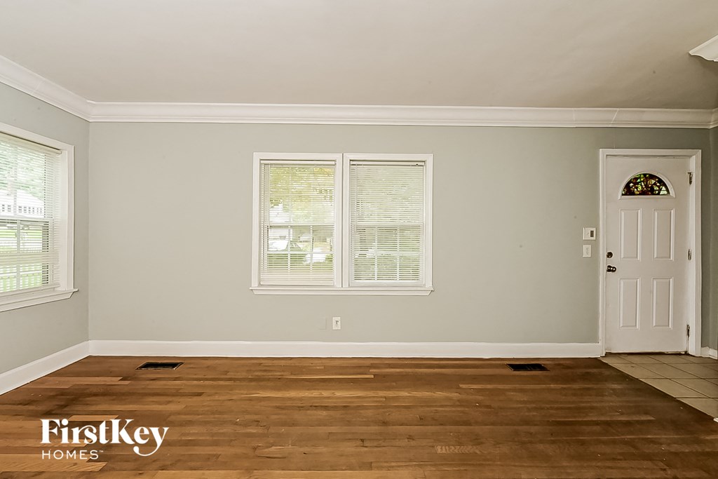 the living room of a home with a wooden floor and a white door
