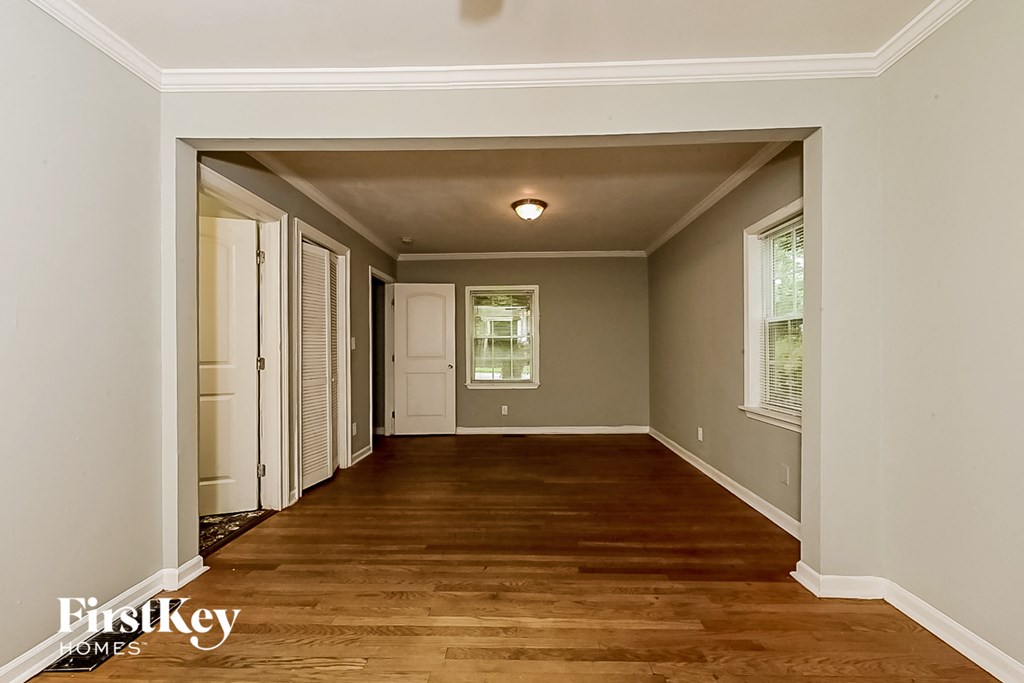 a living room with a hard wood floor and a white door