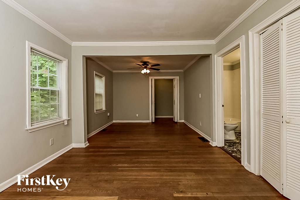 a long hallway with wood floors and a ceiling fan