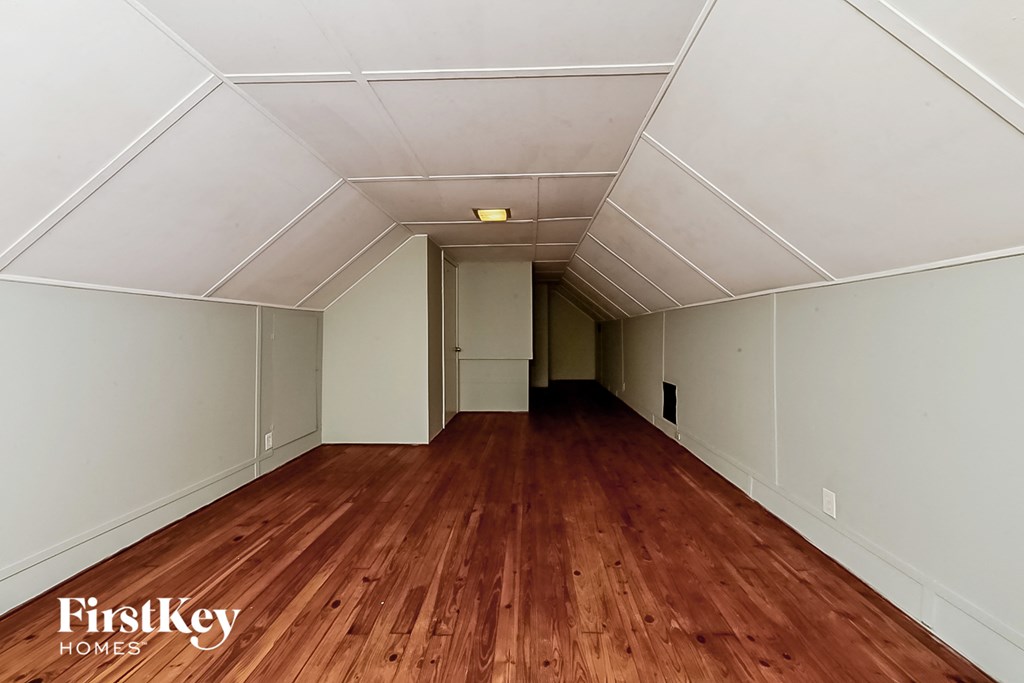 the interior of an empty room with wood floors and white walls