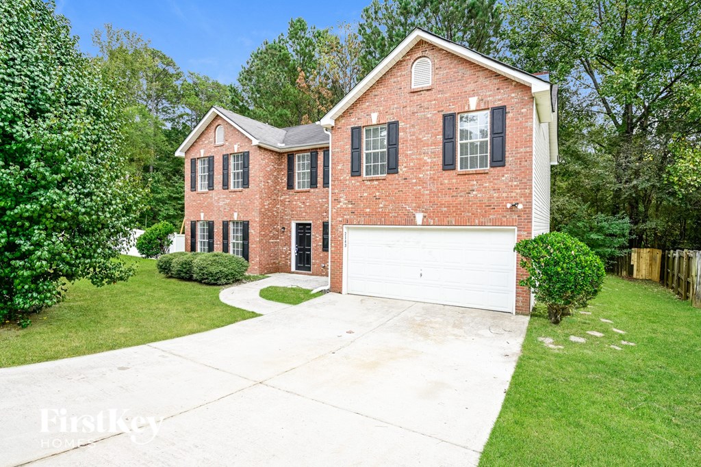 A brick house with a garage and a driveway.