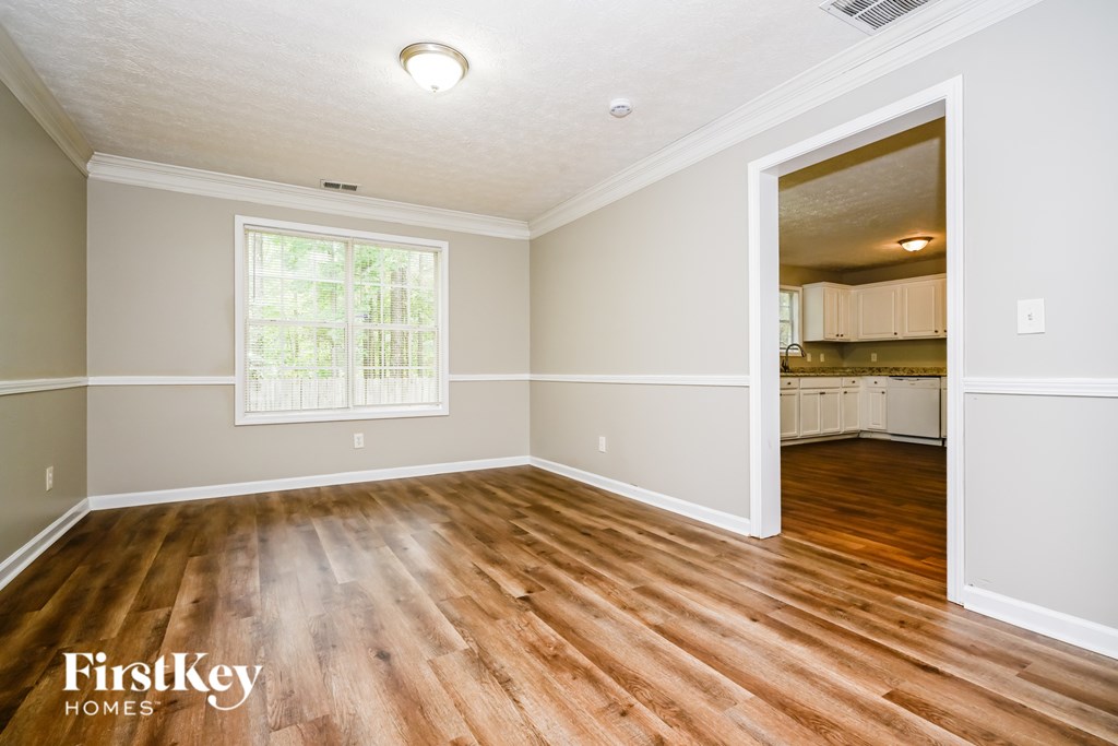 A room with wooden floors and a window is shown.