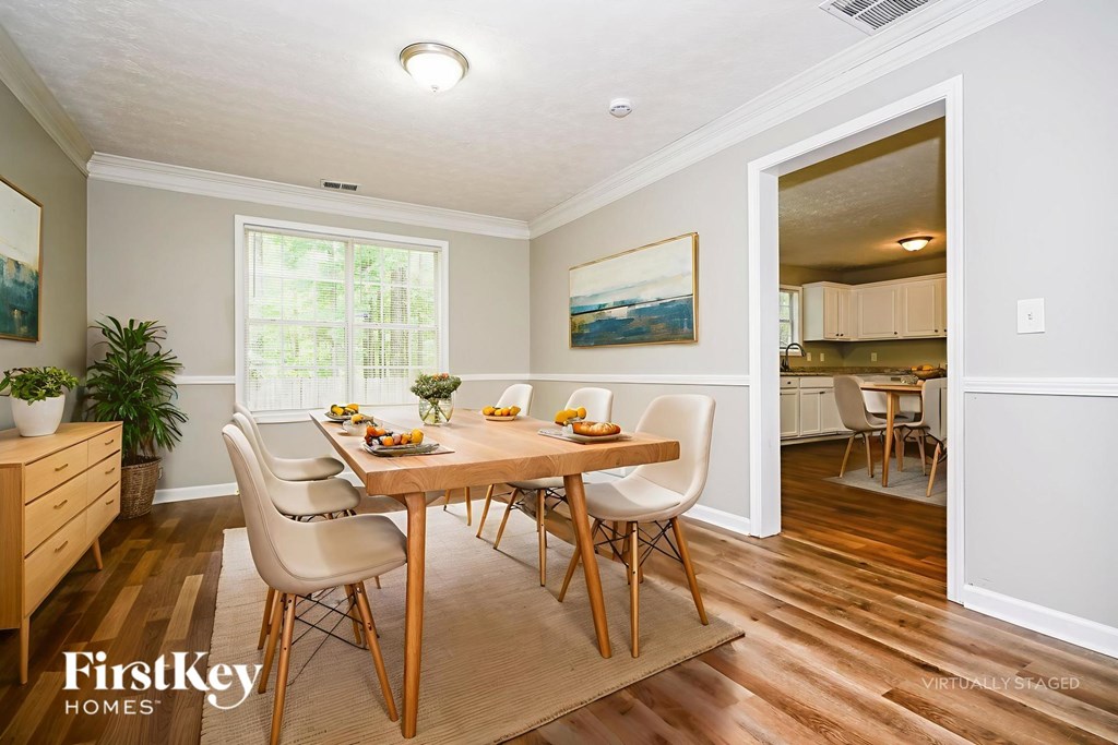 A dining room with a wooden table and chairs.
