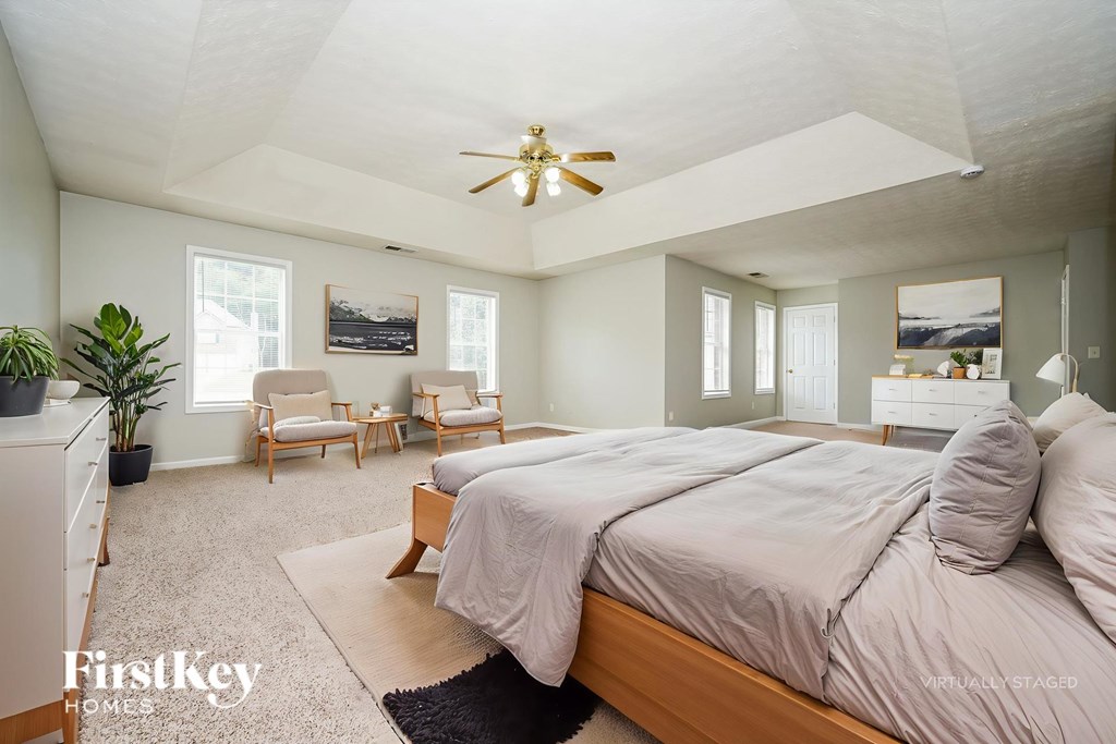A bedroom with a large bed and a ceiling fan.