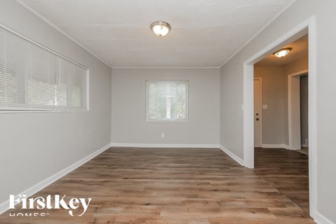 the spacious dining room with hardwood floors and a large window