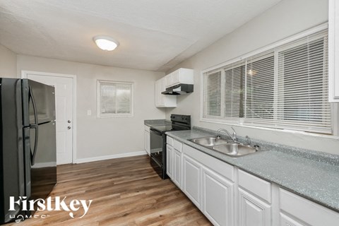 a kitchen with white cabinets and a sink and a refrigerator