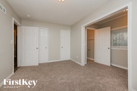 a bedroom with two closets and a carpeted floor