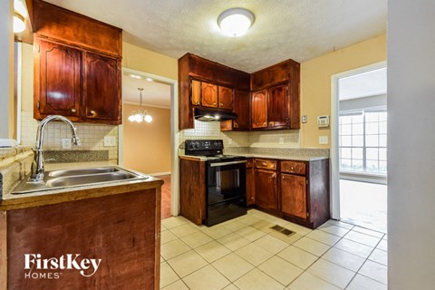 a kitchen with wooden cabinets and a sink and a stove