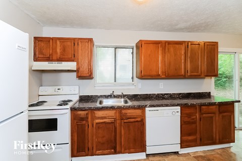 A kitchen with wooden cabinets and a white fridge.