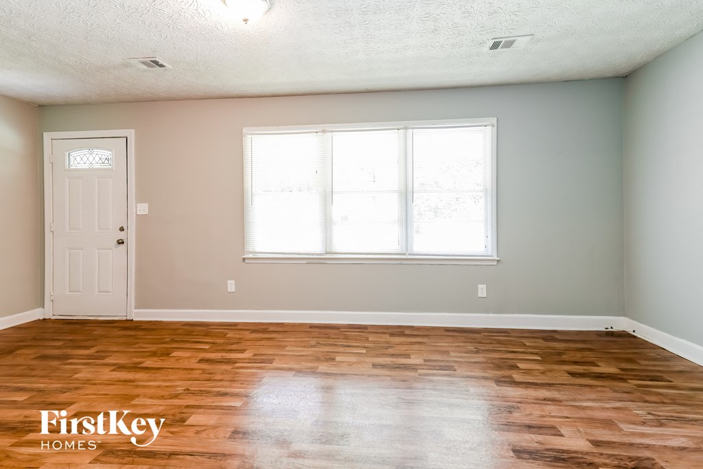 a room with wood floors and a white door and a window