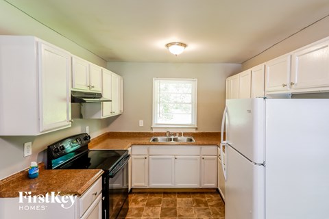 a kitchen with white cabinets and a black stove and refrigerator