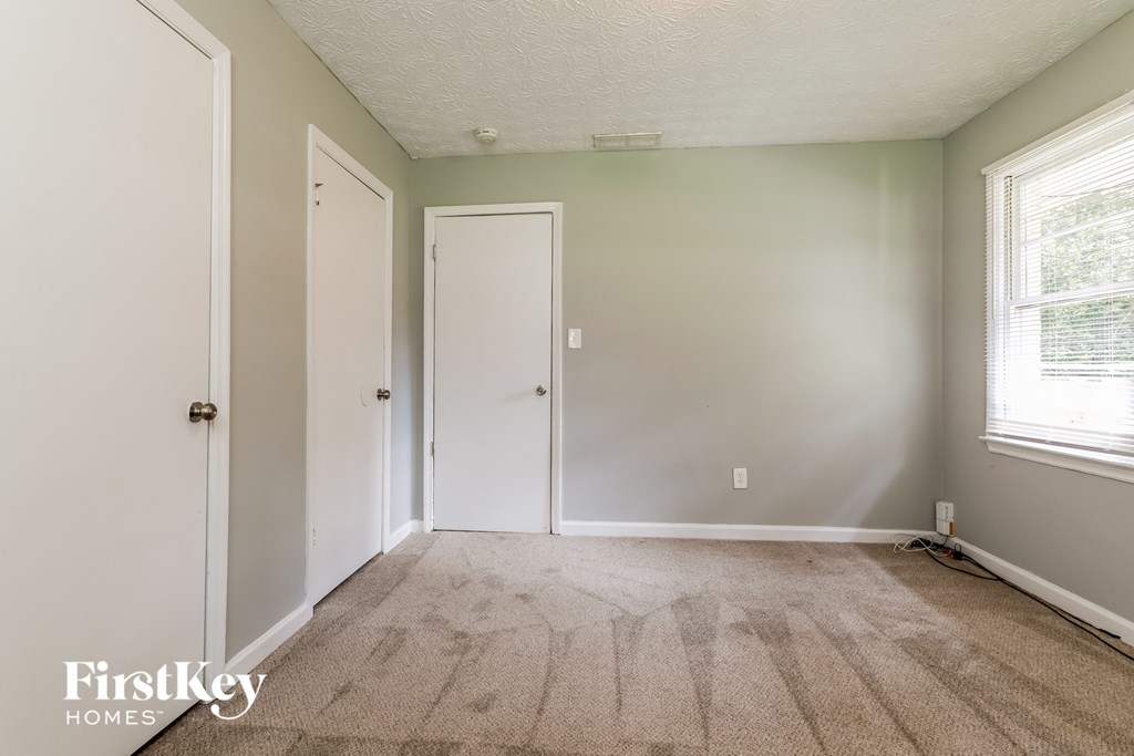 a bedroom with a carpeted floor and a door to a closet