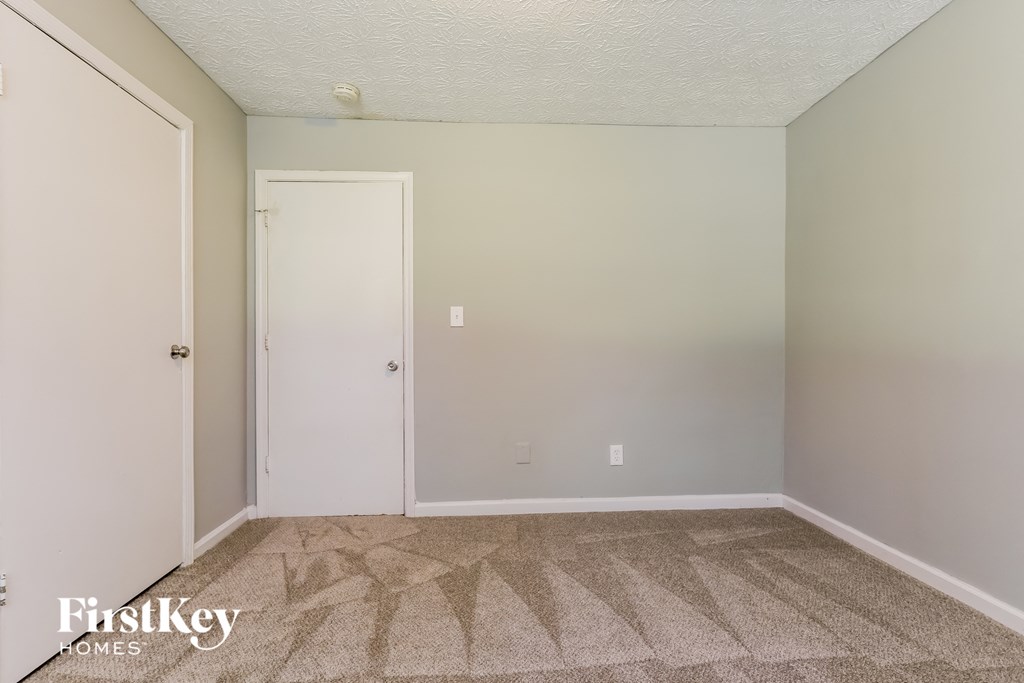 a bedroom with a carpeted floor and a white door