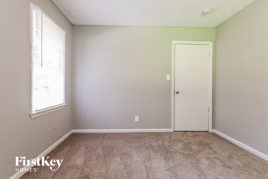 a bedroom with a carpeted floor and a white door