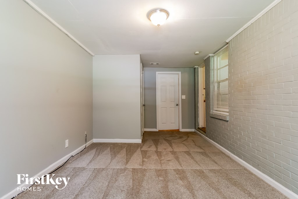 a corridor with a brick wall and a white door and a carpeted flooring