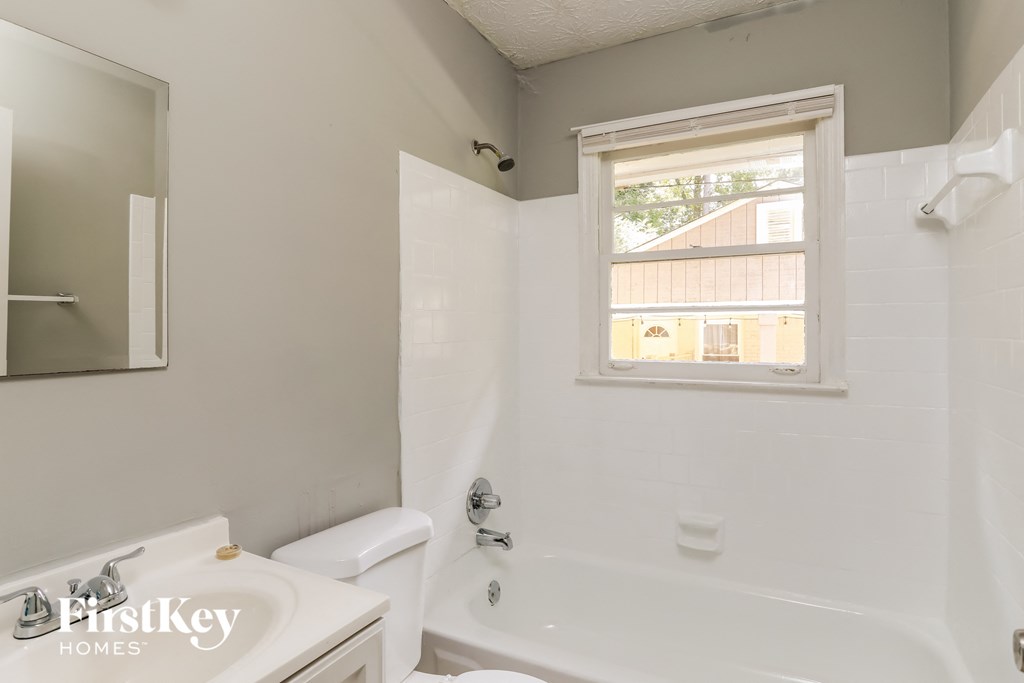 a bathroom with a tub and a sink and a window