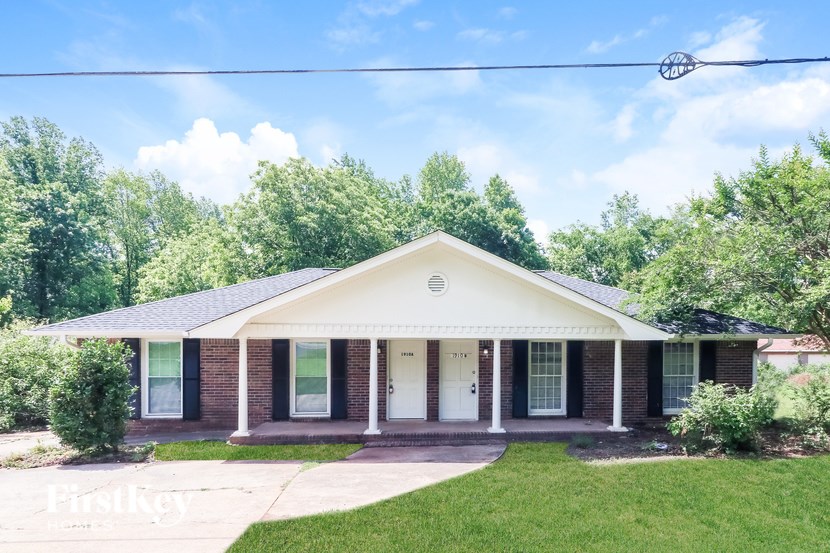 A house with a white front porch and a brick facade.