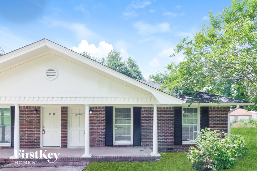 A white house with a porch and a sign that says "FirstKey Homes".