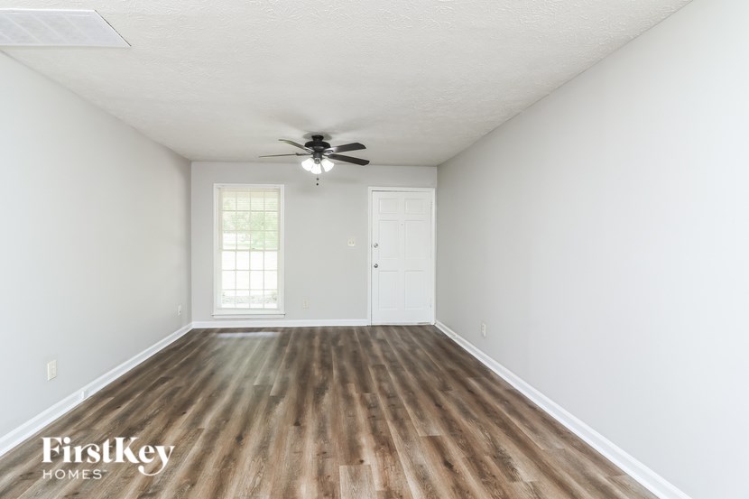 A room with wooden floors and a ceiling fan.