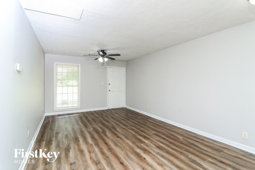 A room with a wooden floor and a ceiling fan.
