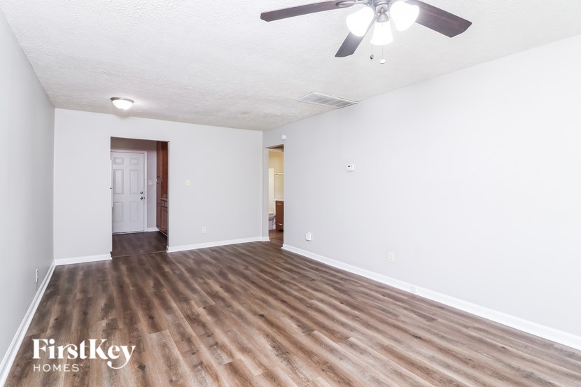 A room with a ceiling fan and wooden flooring.