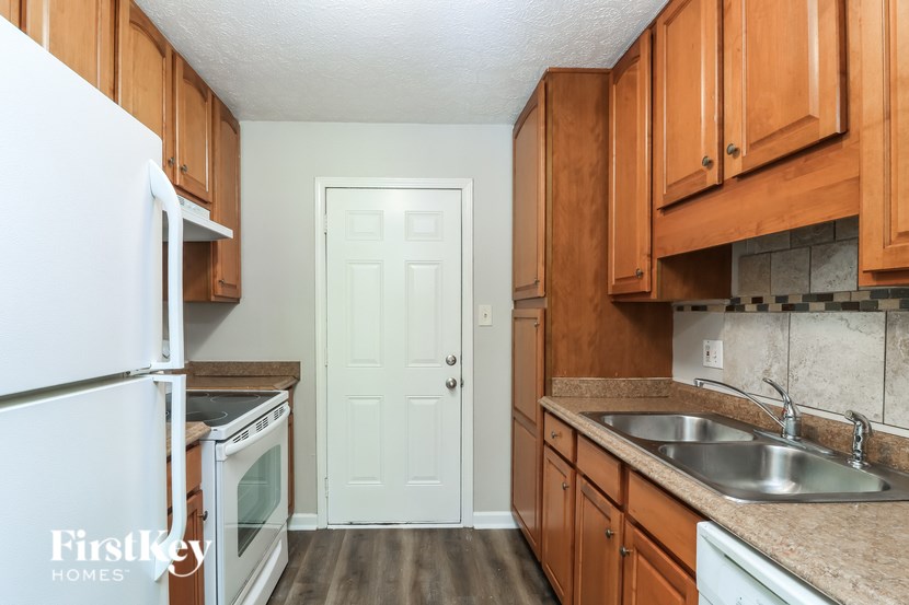 A kitchen with wooden cabinets and a white refrigerator.