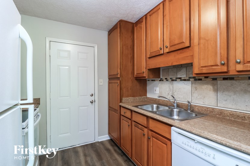 A kitchen with wooden cabinets and a white fridge.