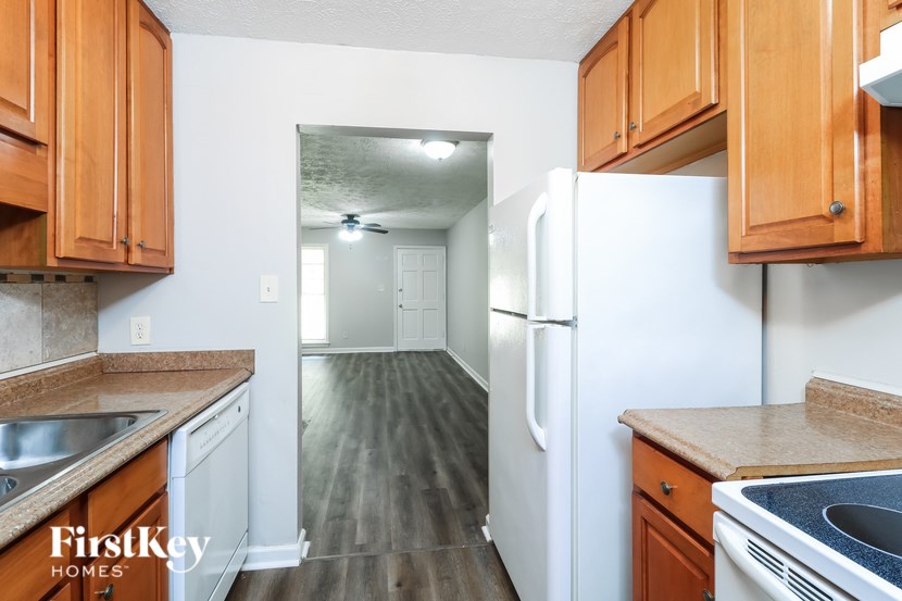 A kitchen with wooden cabinets and a white refrigerator.