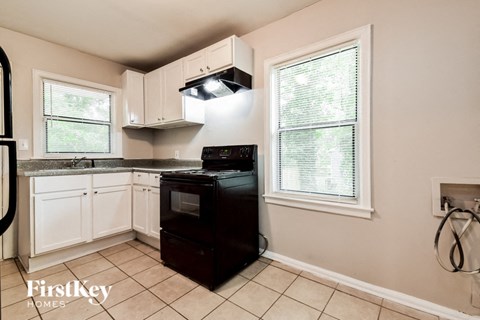 a kitchen with black appliances and white cabinets