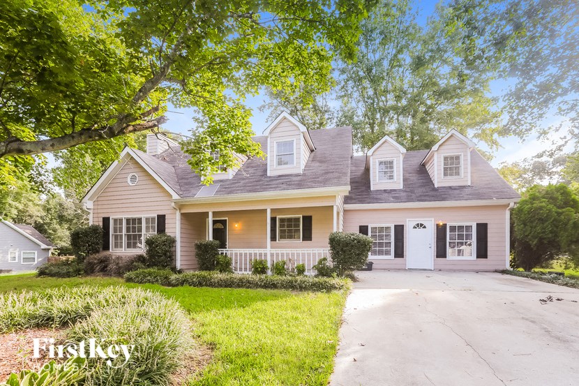 A house with a yellow front and a white garage door.