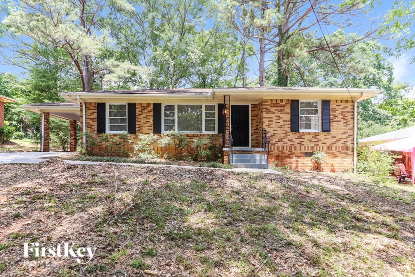 a small brick house with a front yard and trees