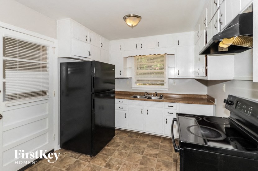 a kitchen with black appliances and white cabinets
