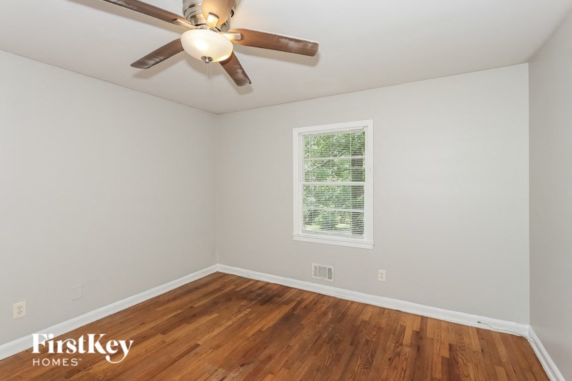 a bedroom with hardwood flooring and a ceiling fan