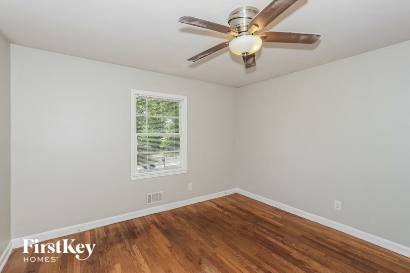 a bedroom with hardwood flooring and a ceiling fan