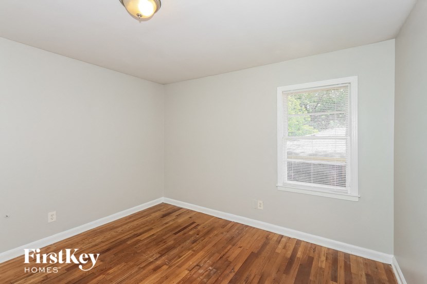 the living room of a house with wood floors and a window