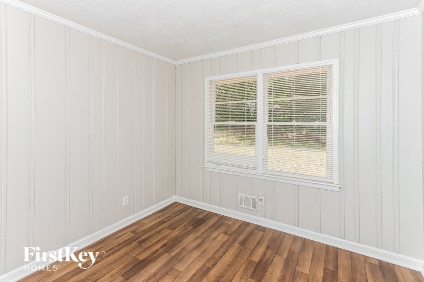 the living room of a home with wood floors and a window