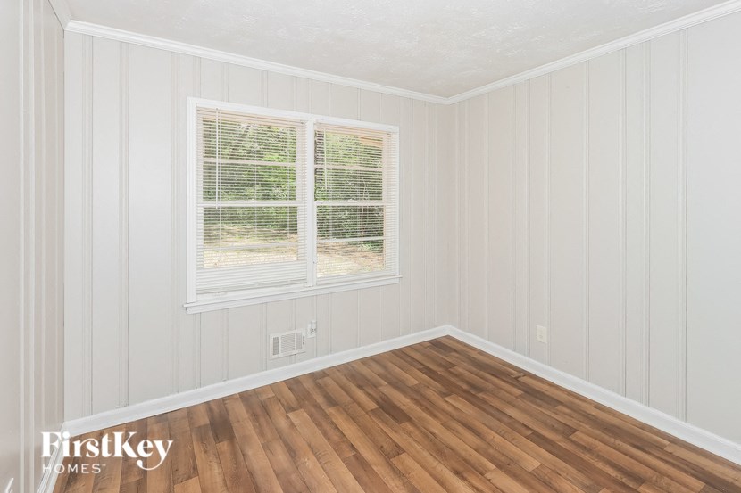 the living room of a home with wood floors and a window