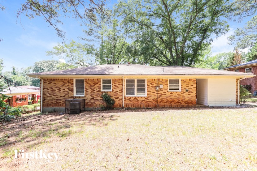 a small brick house with a yard and a tree