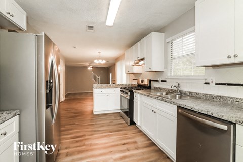 a kitchen with white cabinets and stainless steel appliances and a wood floor