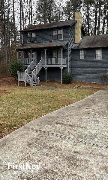 A house with a grey porch and a concrete walkway in front.