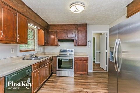 A kitchen with wooden cabinets and a stainless steel refrigerator.