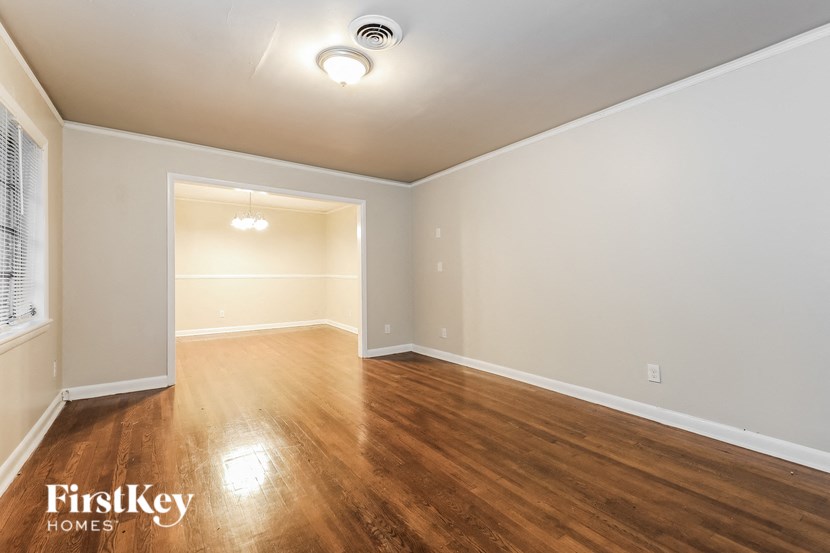 an empty living room with wood floors and white walls
