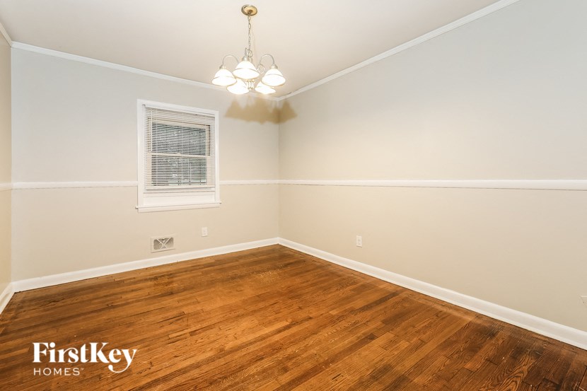 a bedroom with a hardwood floor and a chandelier