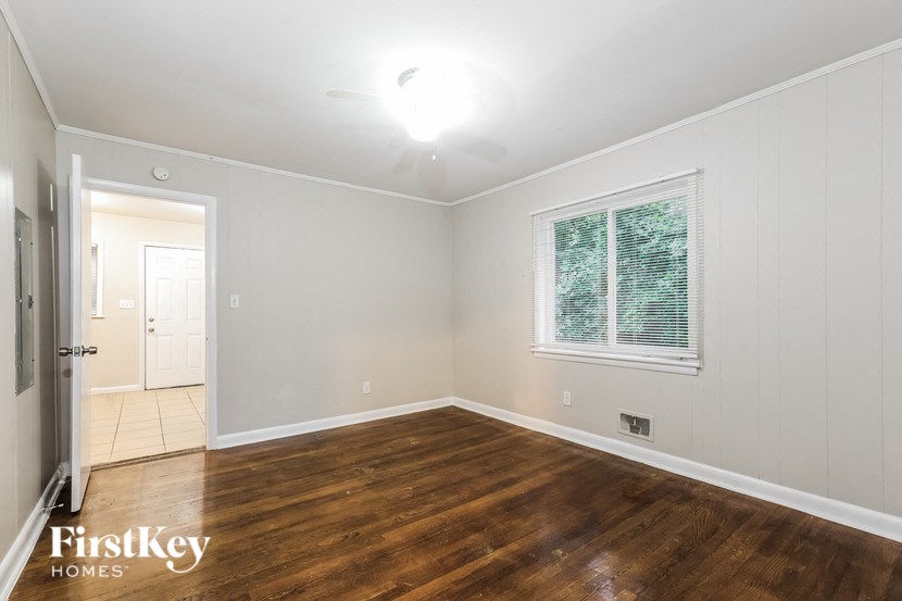an empty living room with wood floors and a window