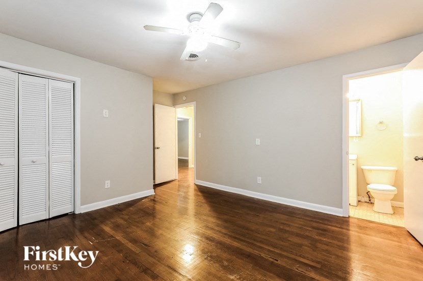 an empty living room with wood flooring and a ceiling fan