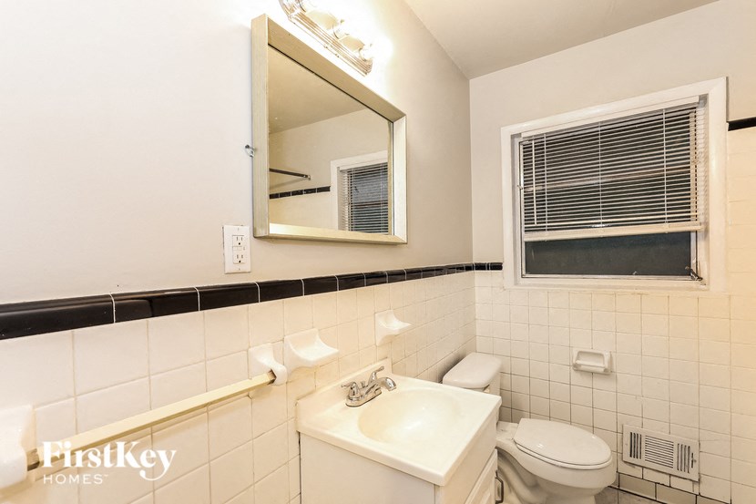a bathroom with a sink toilet and a mirror